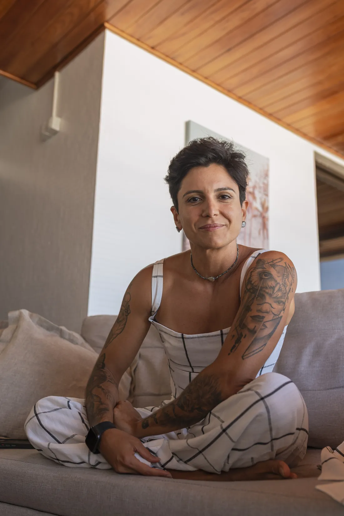Nanny Faggiano sentada no sofá, sorrindo